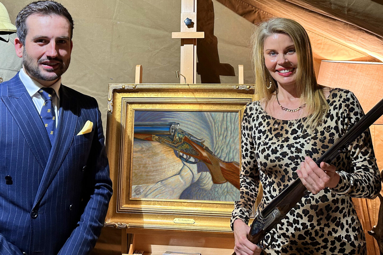 Two people standing next to a painting of a fish.
